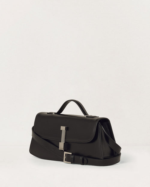 Kassandre Colonne clutch in black cow leather with silver hardware, rigorous lines, adjustable removable strap,crossbody bag, three quarter view