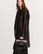 Kassandre Colonne clutch in black cow leather with silver hardware, rigorous lines, worn view