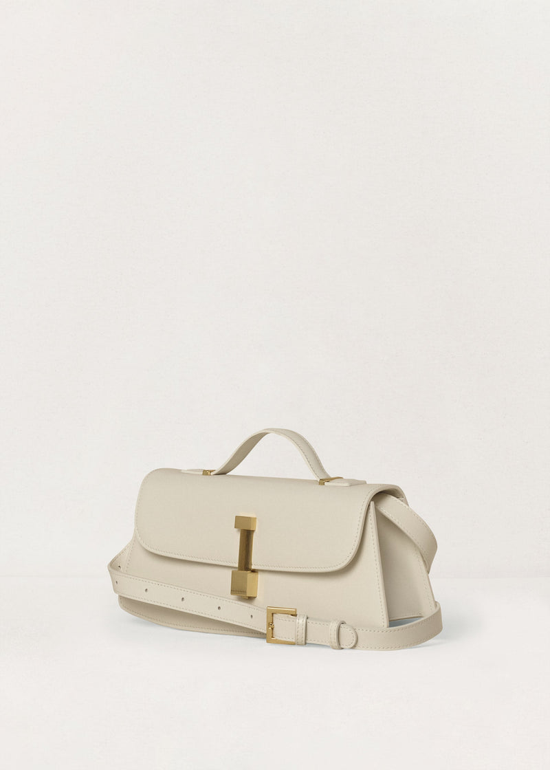 Kassandre Colonne clutch in off-white cow leather with gold hardware, rigorous lines, adjustable removable strap ,crossbody bag, three quarter view