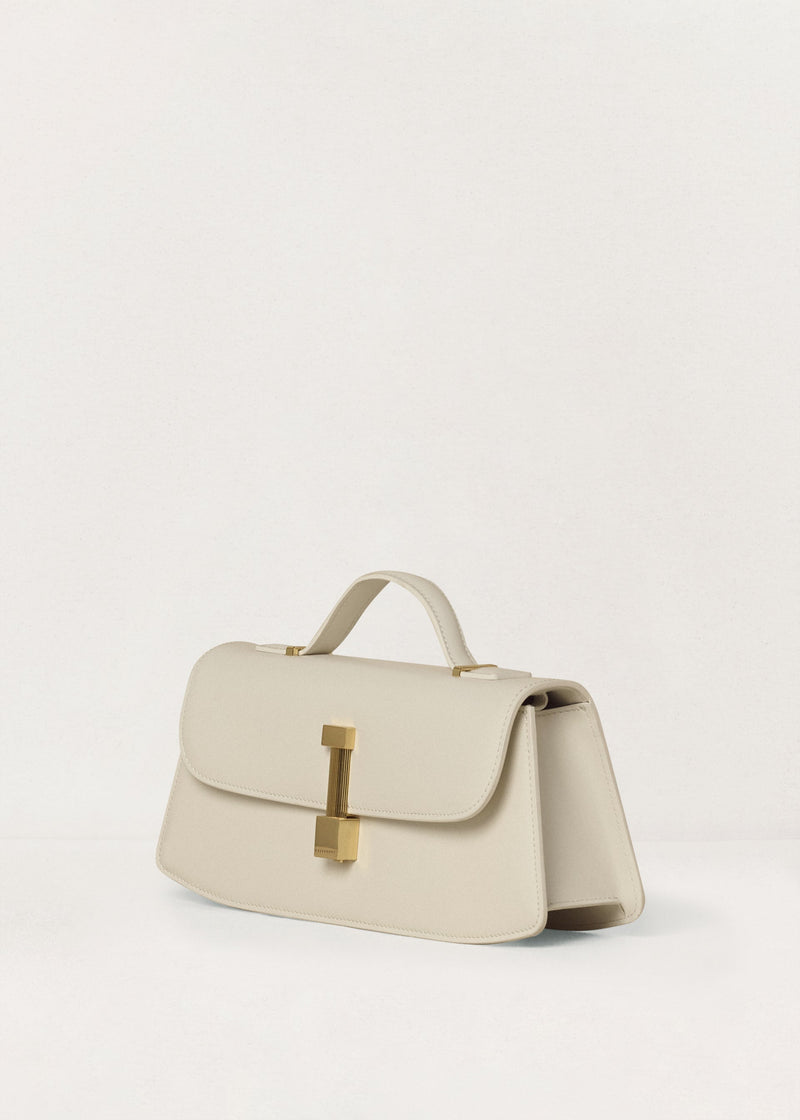 Kassandre Colonne clutch in off-white cow leather with gold hardware, rigorous lines, three quarter view