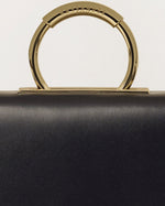 Kassandre Deva clutch in black cow leather with gold hardware, Art Deco geometry,removable strap , crossbody bag , detail view
