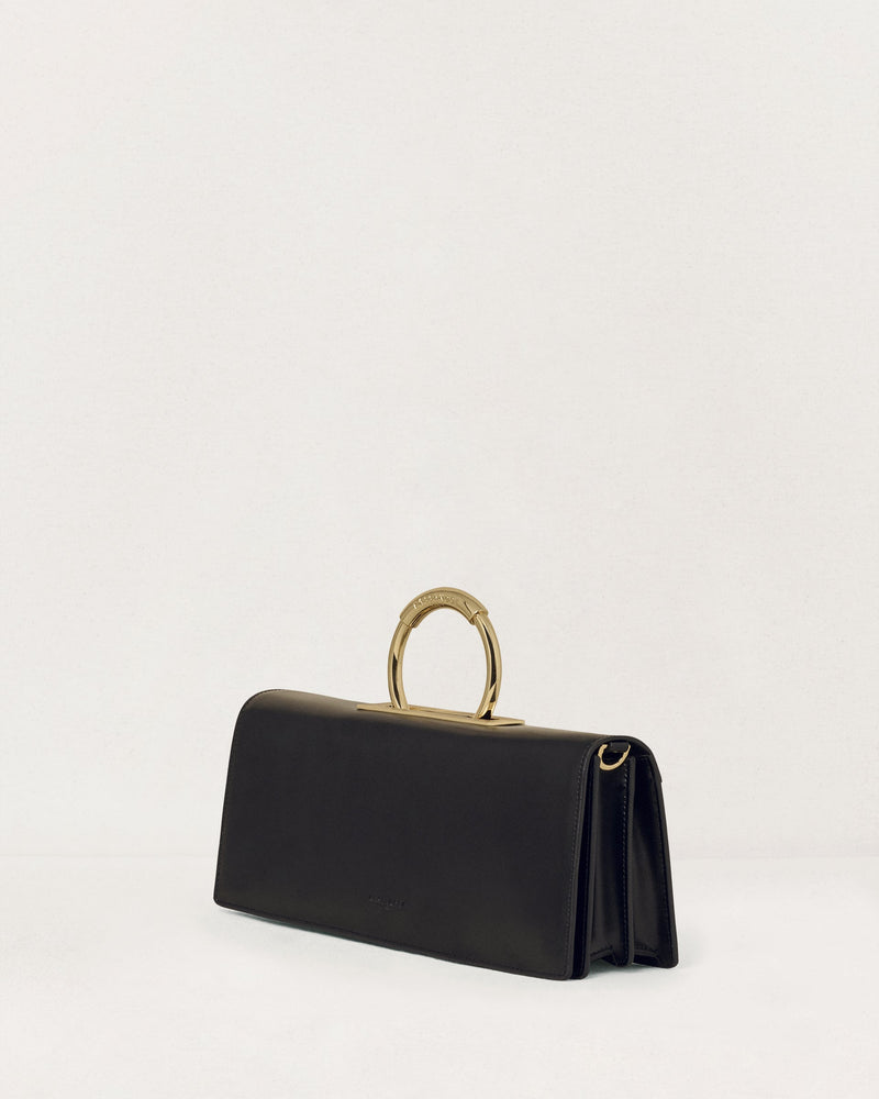 Kassandre Deva clutch in black cow leather with gold hardware, Art Deco geometry,removable strap , crossbody bag , three quarter view