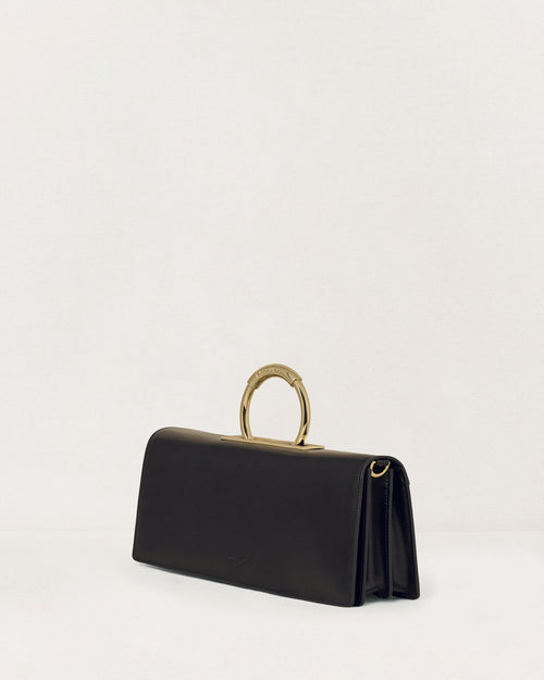 Kassandre Deva clutch in black cow leather with gold hardware, Art Deco geometry,removable strap , crossbody bag , three quarter view