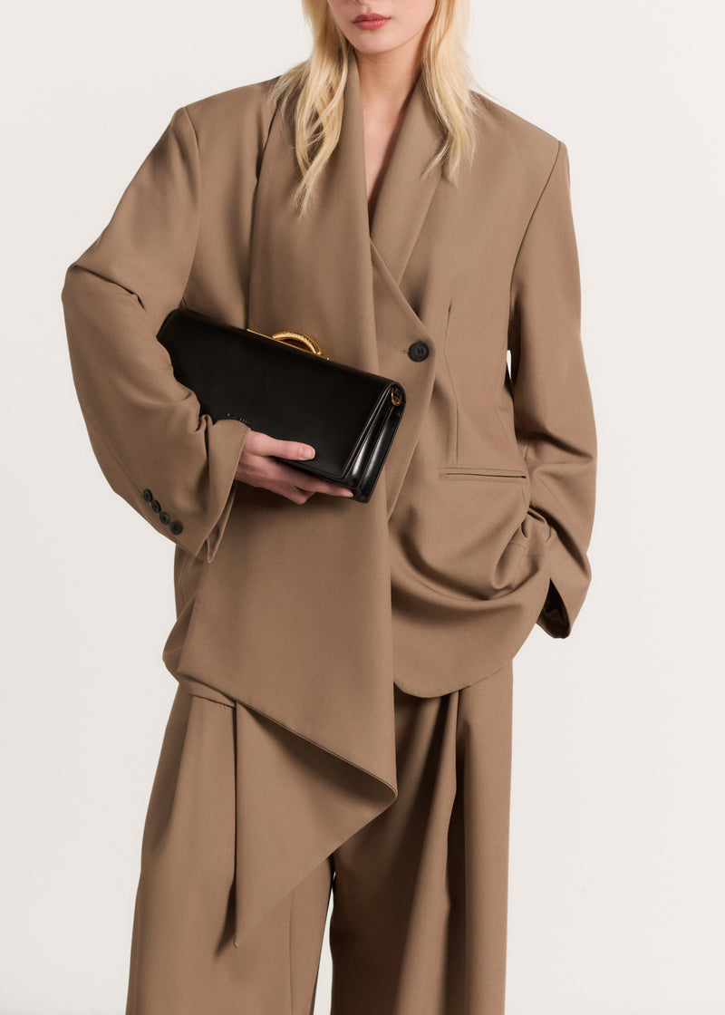 Kassandre Deva clutch in black cow leather with gold hardware, Art Deco geometry,removable strap , crossbody bag , worn view