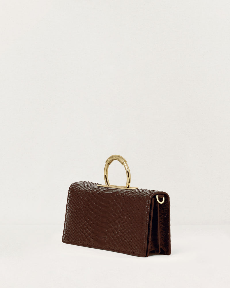 Kassandre Deva clutch in brown python-effect leather, sculptural Art Deco geometry, removable strap , crossbody bag ,three quarter view