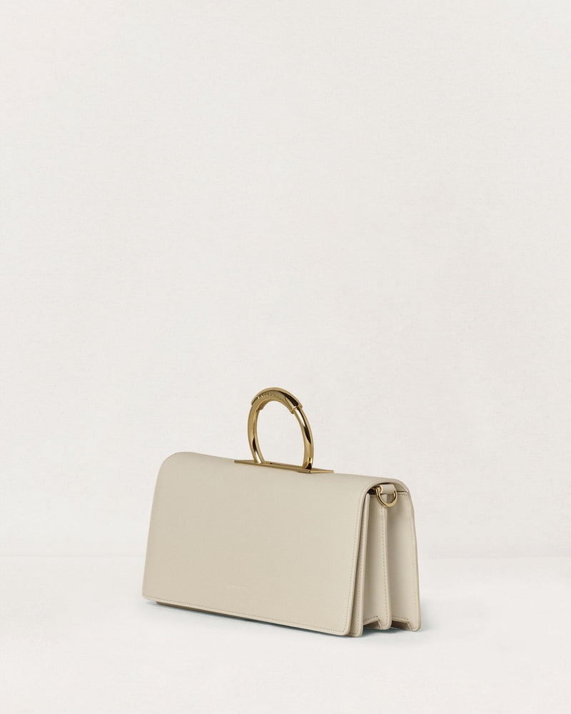 Kassandre Deva clutch in off-white cow leather, pure geometric form, adjustable strap, removable strap , crossbody bag ,three quarter view