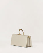 Kassandre Deva clutch in off-white cow leather, pure geometric form, adjustable strap, removable strap , crossbody bag ,three quarter view