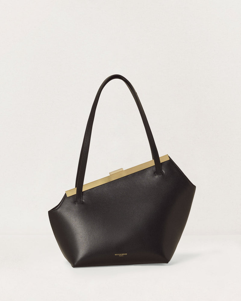 Kassandre Eileen asymmetric shoulder bag in black cow leather, architectural line, front view