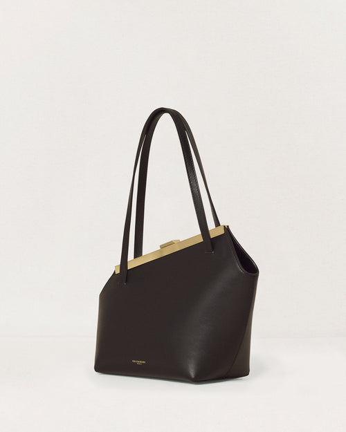 Kassandre Eileen asymmetric shoulder bag in black cow leather, architectural line, gold frame,three quarter view