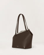 Kassandre Eileen asymmetric shoulder bag in brown cow leather, silver frame, graphic geometry, three quarter view 