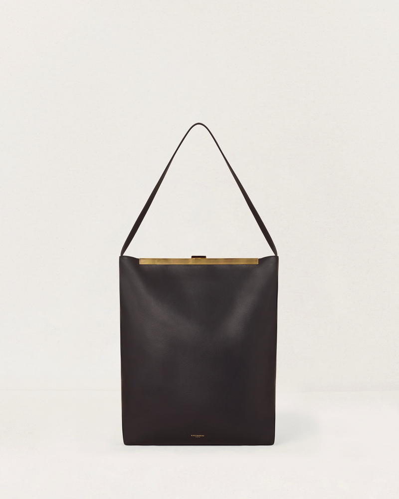 Kassandre Eileen computer bag in black cow leather with gold striped metal frame, front view