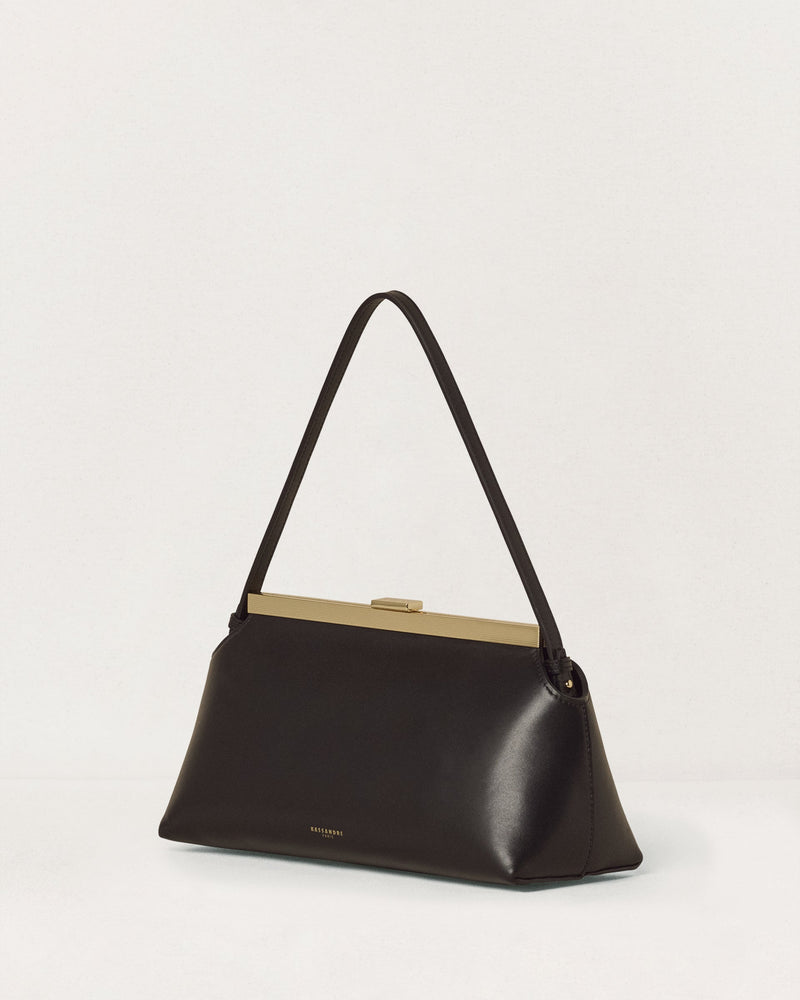 Kassandre Eileen shoulder bag in black smooth cow leather with striped metal frame, three quarter view