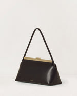 Kassandre Eileen shoulder bag in black smooth cow leather with striped metal frame, three quarter view
