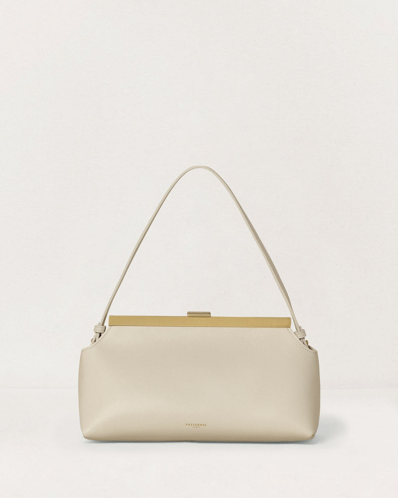 Kassandre Eileen shoulder bag in off-white cow leather with gold striped metal frame, front view