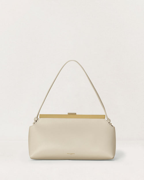Kassandre Eileen shoulder bag in off-white cow leather with gold striped metal frame, front view